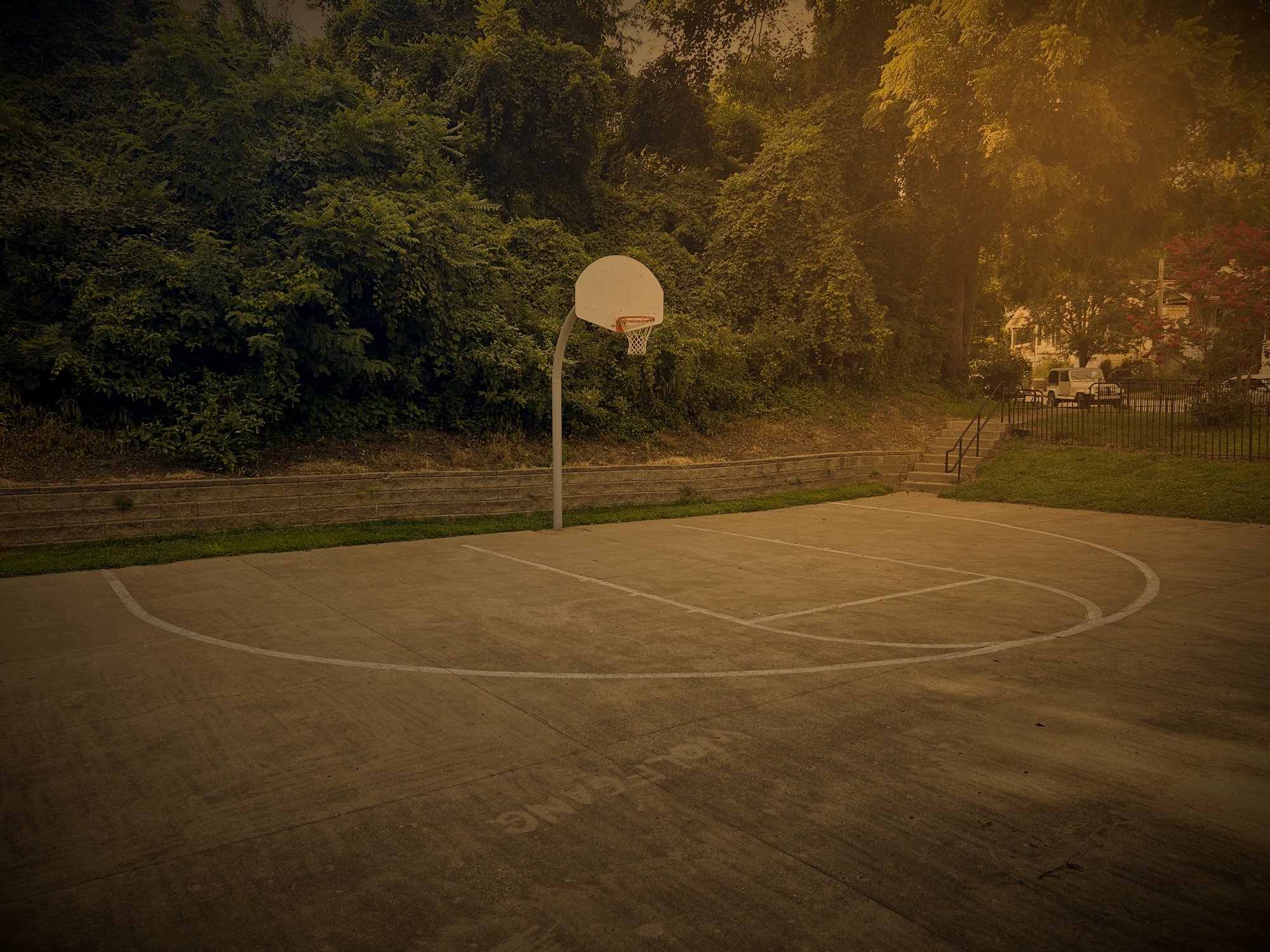 Outdoor concrete basketball court at Swope in late evening light
